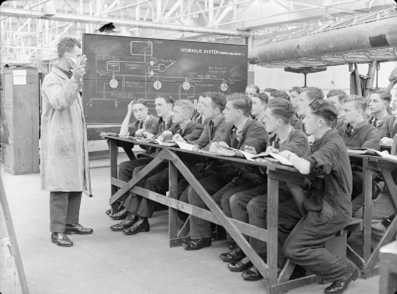 Royal Air Force Technical Training Command, 1940-1945. An instructor lectures to aircraft apprentices on the working of an aircraft hydraulic system, in the workshops at No. 1 School of Technical Training, Halton, Buckinghamshire.
